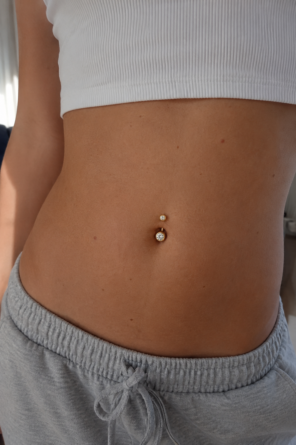 14kt. Geelgouden Navelpiercing – Heldere Steen – 1.6 mm – 4×6 mm gedragen door model