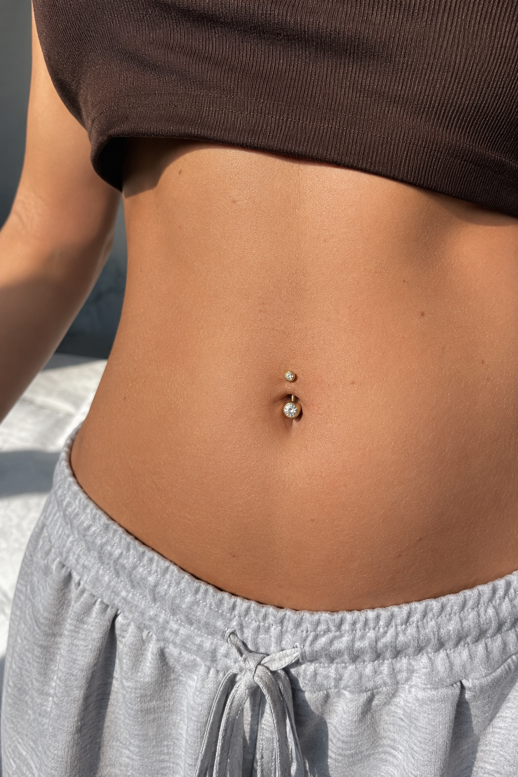 14kt. Geelgouden Navelpiercing – Heldere Steen – 1.6 mm – 4×6 mm gedragen door model