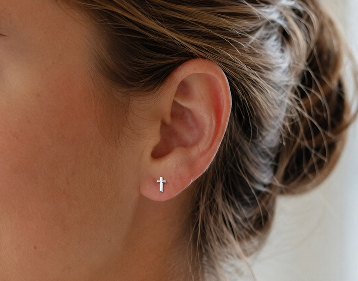 14kt. Gouden Setje Oorstuds met Kruis Top – Witgoud – 0.8 mm gedragen door model