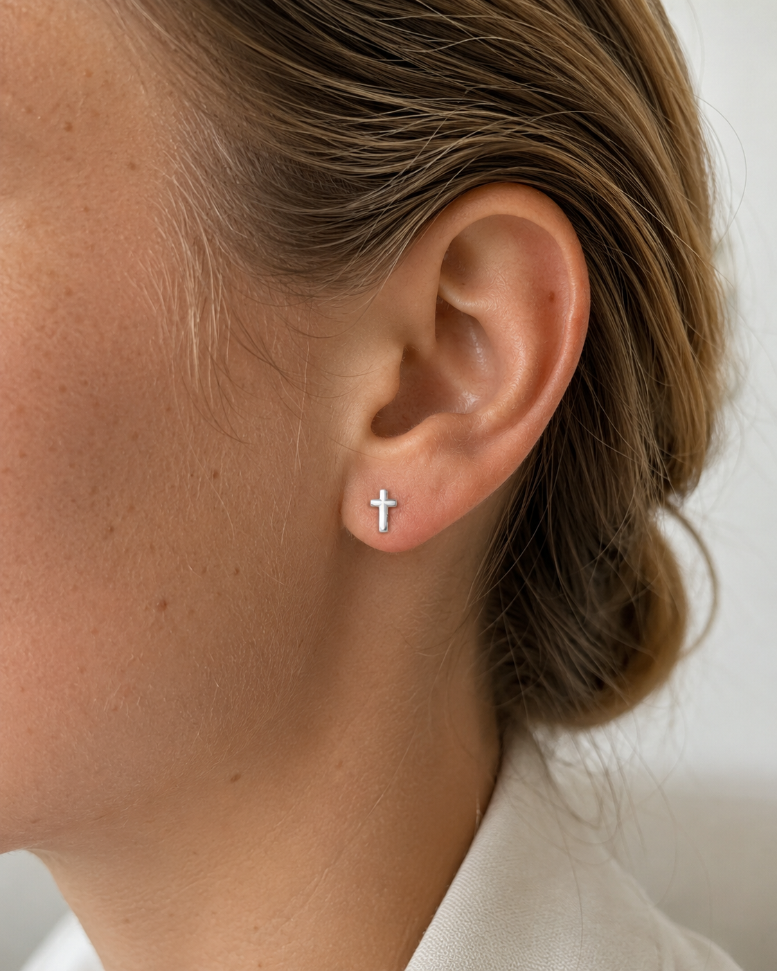14kt. Gouden Setje Oorstuds met Kruis Top – Witgoud – 0.8 mm gedragen door model