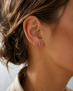 14kt. Gouden Setje Oorstuds met Kruis Top – Geelgoud – 0.8 mm gedragen door model
