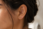 14kt. Gouden Setje Oorstuds met Infinity – Geelgoud – 0.8 mm gedragen door model