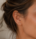 14kt. Gouden Setje Oorstuds met Infinity – Geelgoud – 0.8 mm gedragen door model