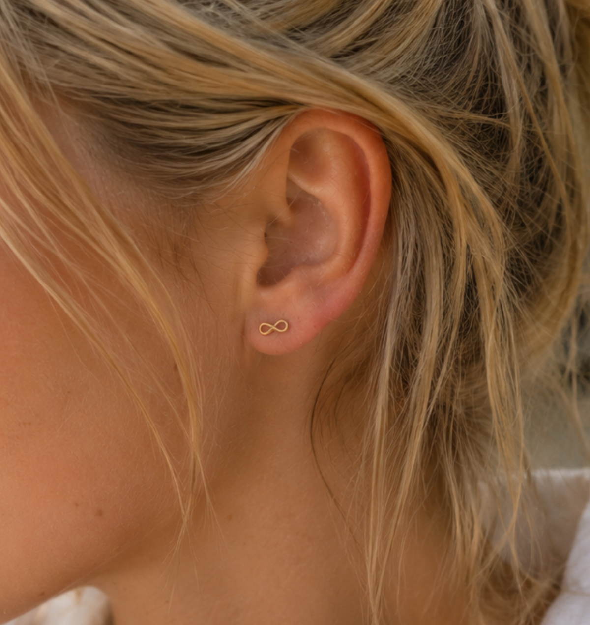 14kt. Gouden Setje Oorstuds met Infinity – Geelgoud – 0.8 mm gedragen door model