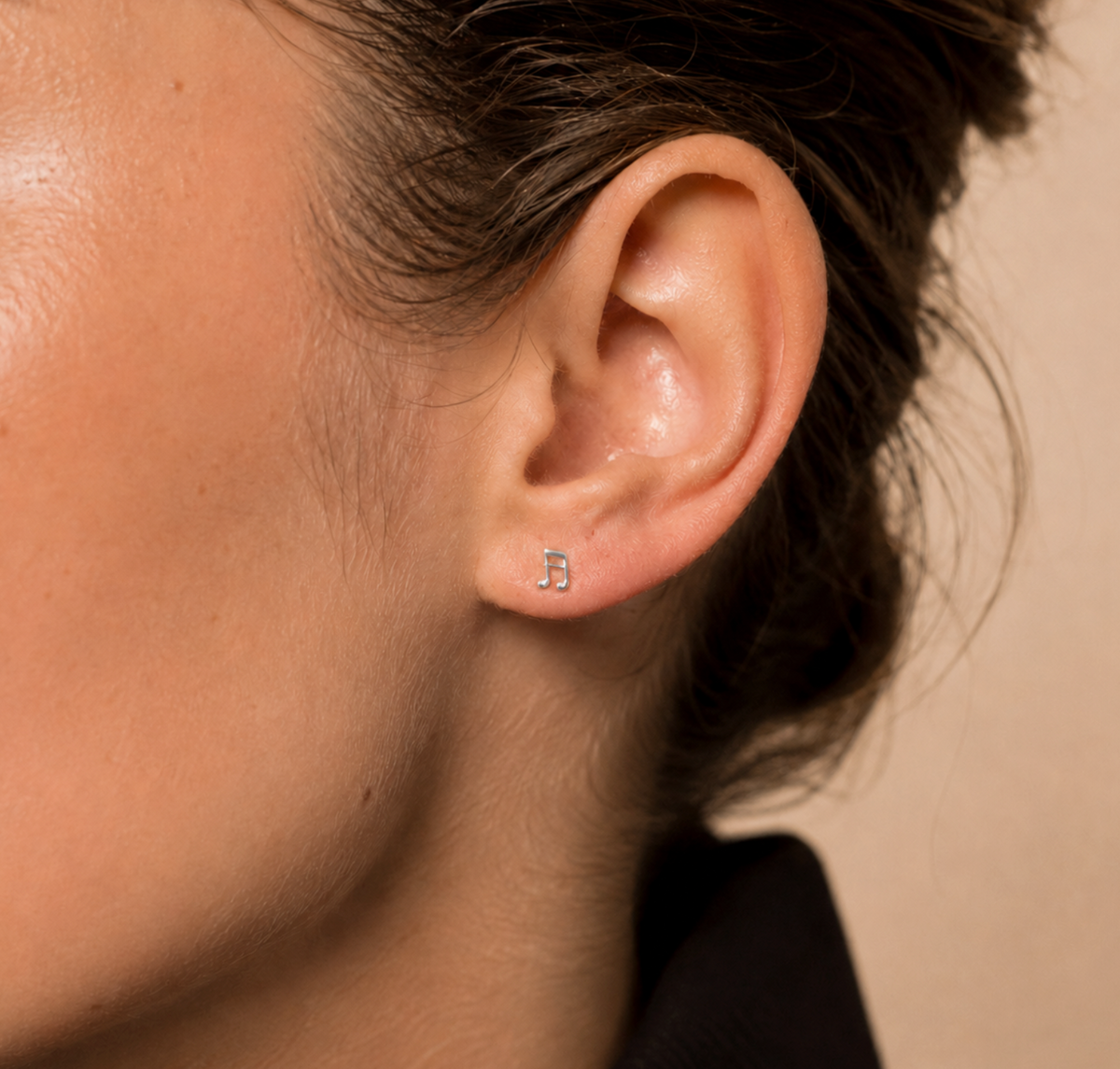 14kt. Gouden Setje Oorstuds met Muzieknoot – Witgoud – 0.8 mm gedragen door model