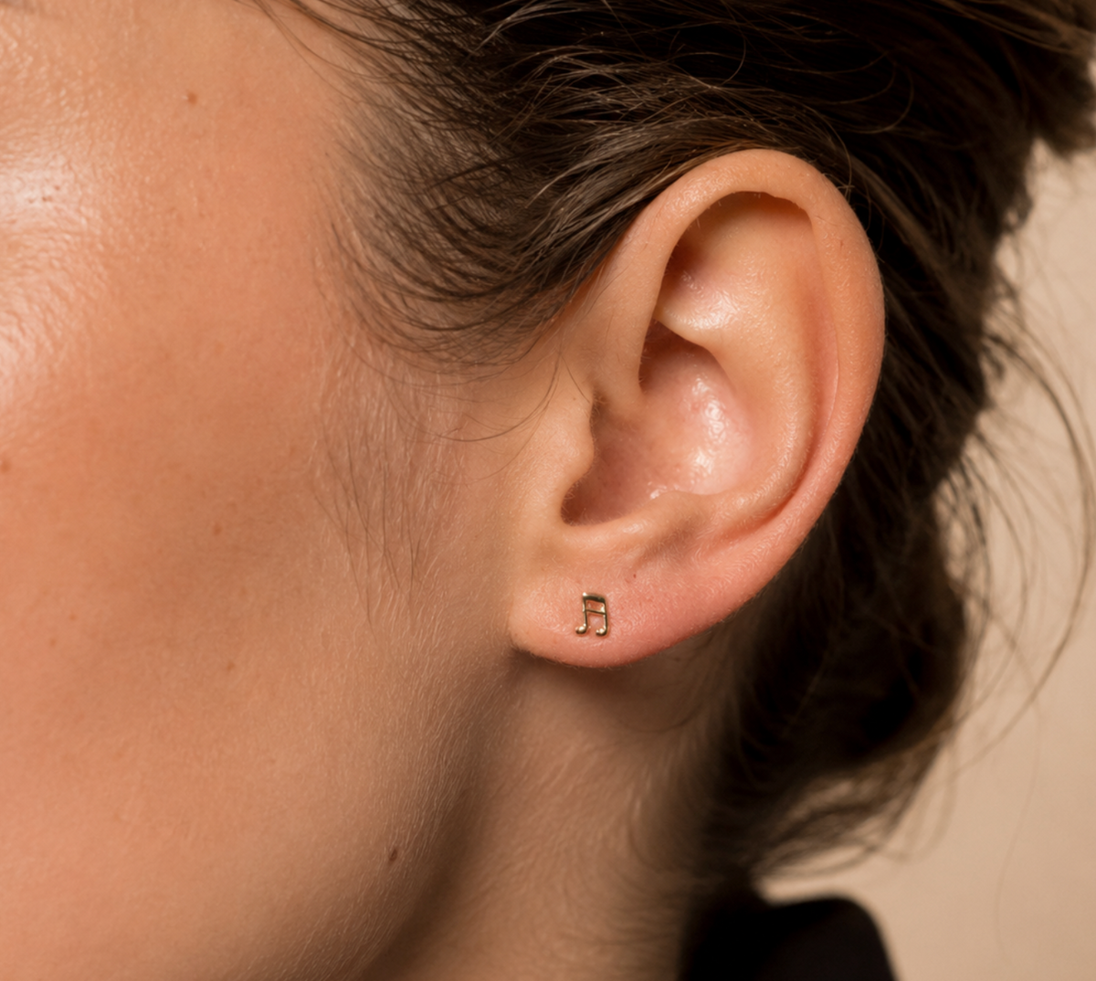 14kt. Gouden Setje Oorstuds met Muzieknoot – Geelgoud – 0.8 mm gedragen door model