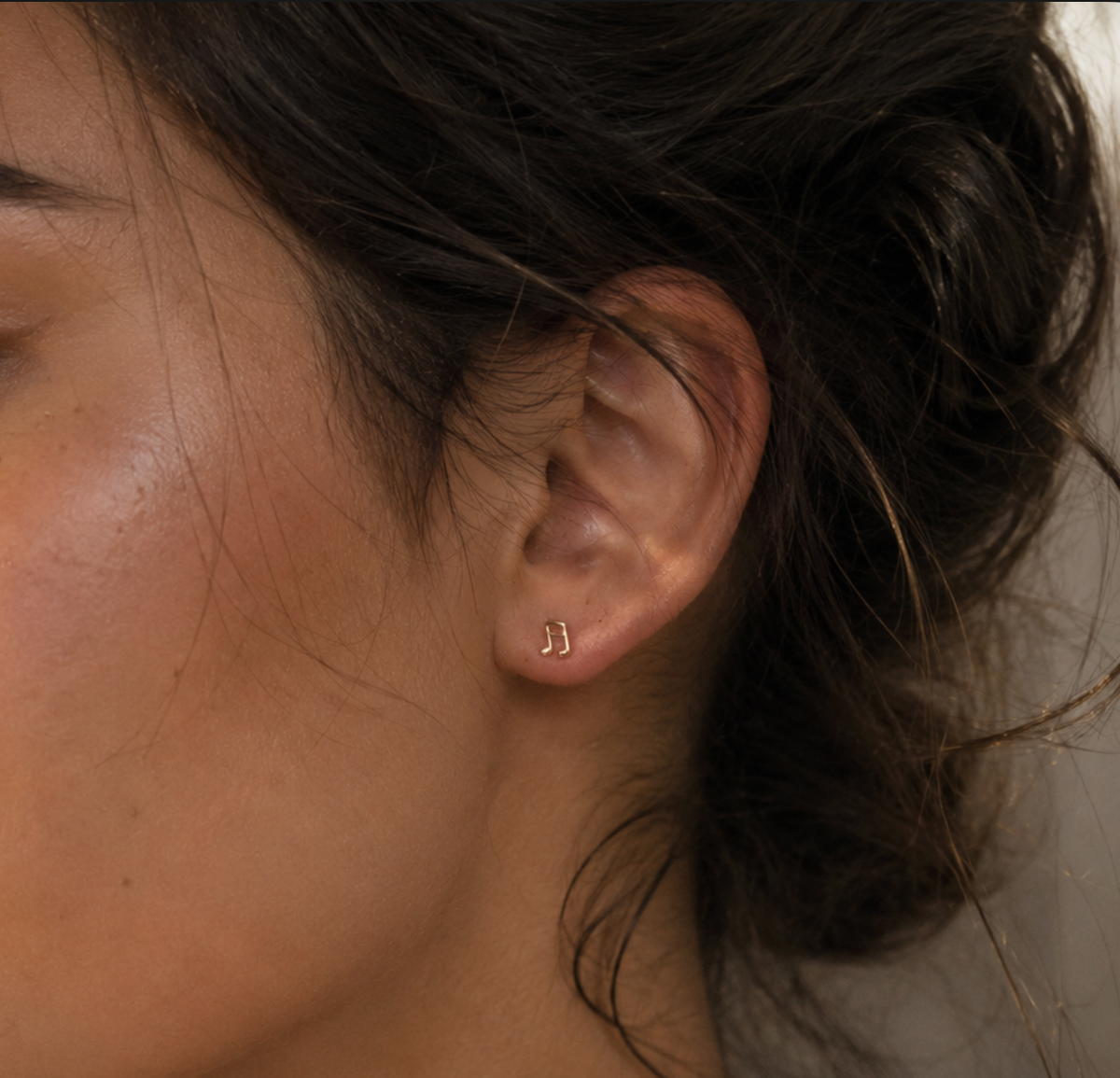 14kt. Gouden Setje Oorstuds met Muzieknoot – Geelgoud – 0.8 mm gedragen door model