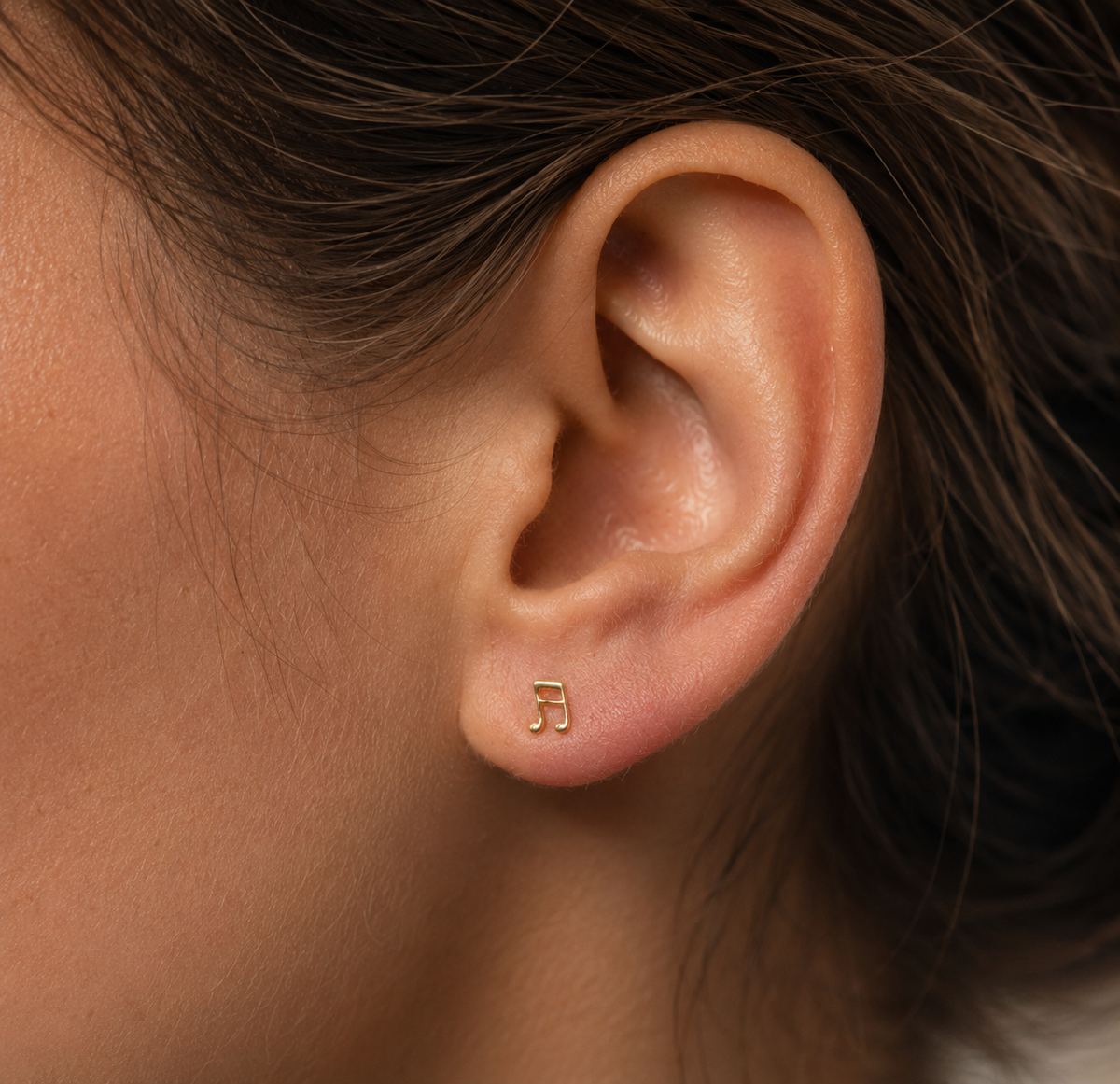14kt. Gouden Setje Oorstuds met Muzieknoot – Geelgoud – 0.8 mm gedragen door model