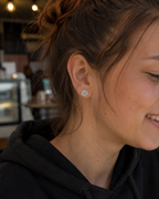 14kt. Gouden Setje Oorstuds met Roos Top – Witgoud – 0.8 mm gedragen door model