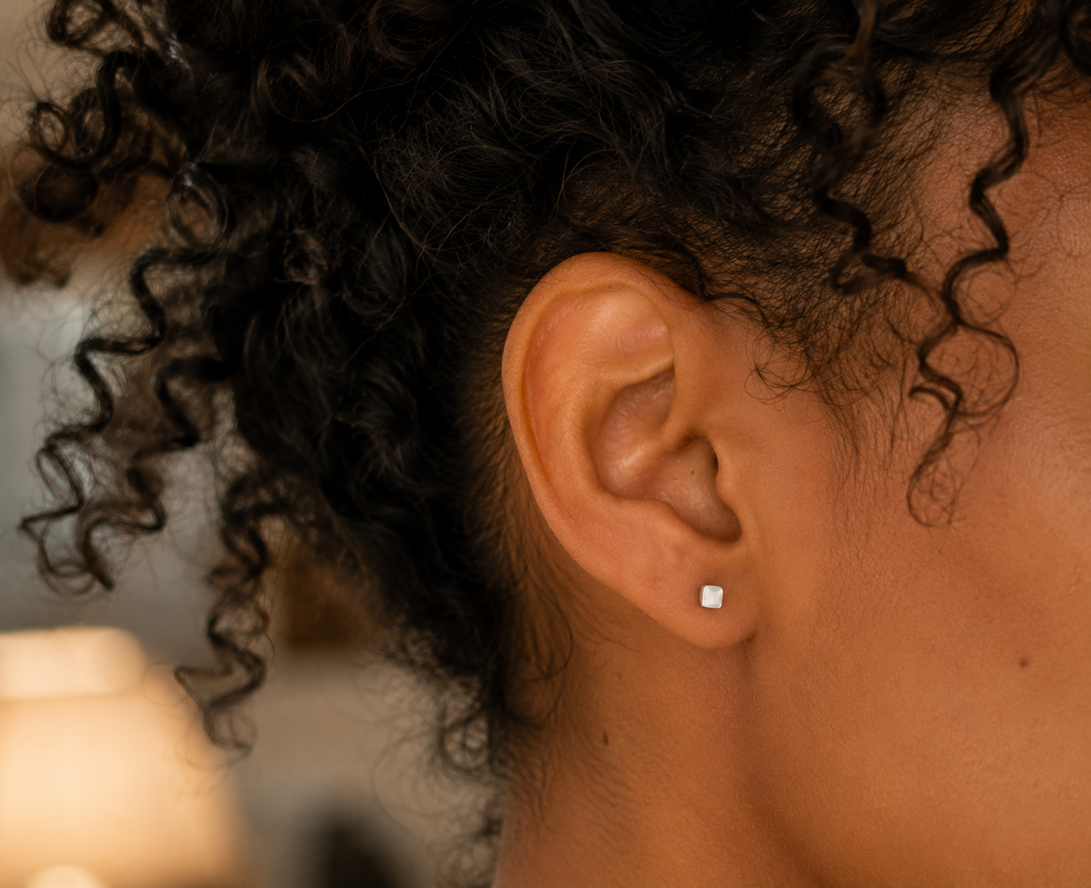 14kt. Gouden Setje Oorstuds met Vierkante Top – Witgoud – 0.8 mm gedragen door model